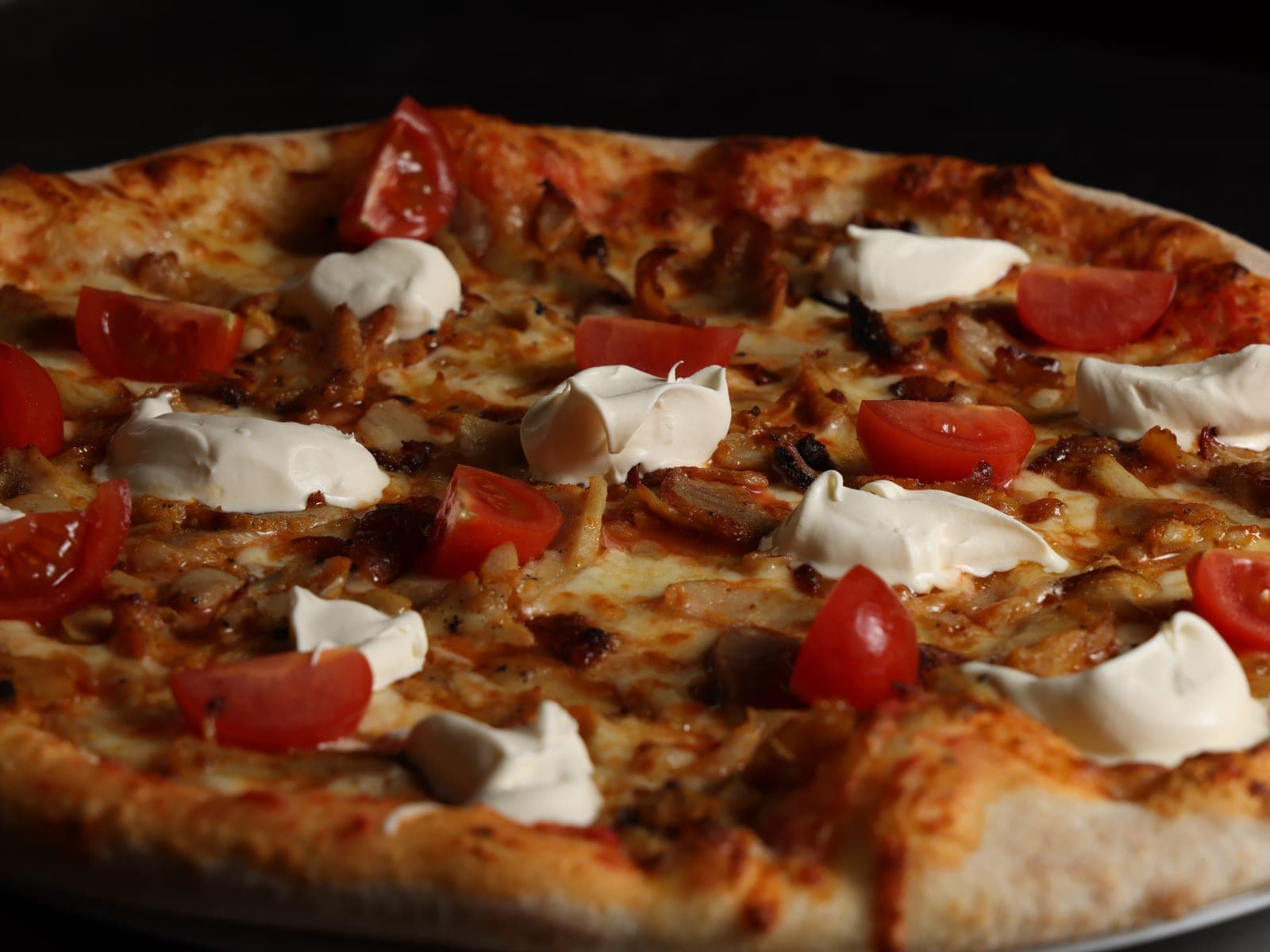 Pizza mit Tomaten und frischen Zutaten